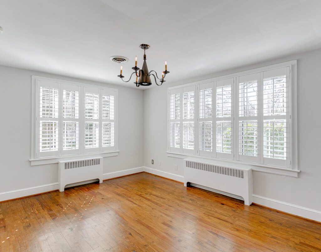 empty room with window plantation shutters black chandelier gothic gas heater