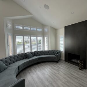 Large living room with white plantation shutters or indoor shutters on the windows.