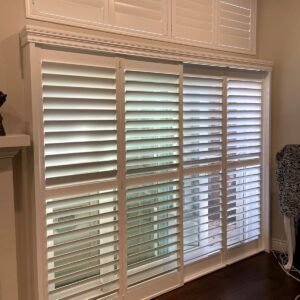 White plantation shutters, or indoor shutters, on a sliding glass door.